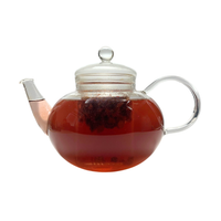 Teekanne aus Glas mit flüssigem Johannisbeere Himbeere Erdbeere Beeren Früchtetee und losen Früchten