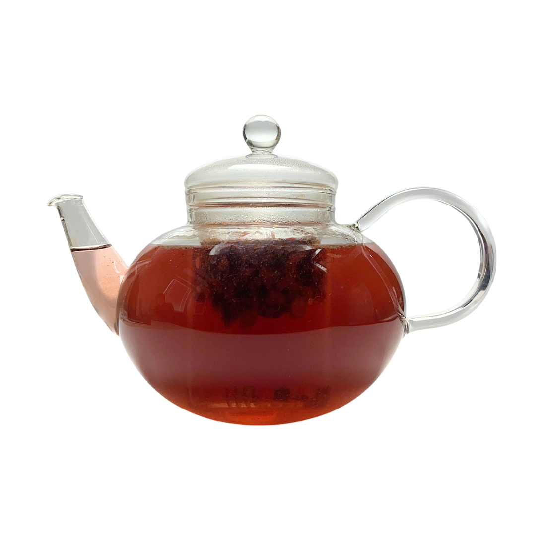 Teekanne aus Glas mit flüssigem Orange Ingwer Zimt Früchtetee und losen Früchten