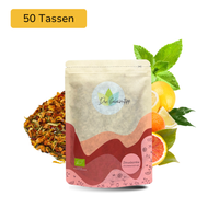 Der Geheimtipp Zitrusbombe Tee Verpackung aus Papier mit losem Blutorange Zitrone Minze Früchtetee im Hintergrund